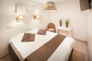 ein Schlafzimmer mit einem großen weißen Bett und einem Stuhl in der Unterkunft Parkhotel in De Panne