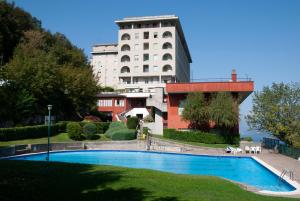 a hotel with a swimming pool in front of a building at LAGO DI COMO LAKE APARTMENT CASA VACANZe in Valbrona