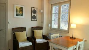 een eetkamer met een tafel en stoelen en een raam bij Doubs Le Cadran Solaire, gite ROMANCE class 3 étoiles in Sancey-le-Grand
