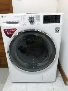 a white washing machine sitting in a room at Holiday House, São Roque do Pico in Cais do Pico