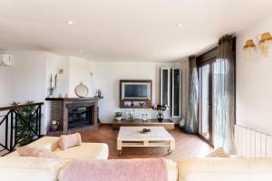 ein Wohnzimmer mit 2 Sofas und einem Kamin in der Unterkunft Holiday Home El Encinar in Alcaucín