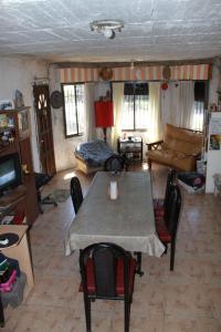 uma sala de estar com uma mesa e cadeiras e um sofá em HOSTEL la Casa del Patio BB em Bahía Blanca