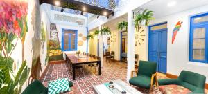 una hall con porte blu e sedie verdi di Granada Hostel a Bogotá
