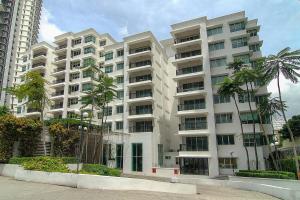 un gran edificio blanco con palmeras delante en Wedgewood Residences, en Kuala Lumpur