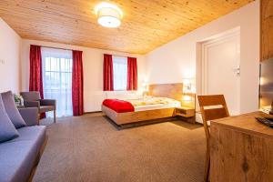 sypialnia z łóżkiem i kanapą w pokoju w obiekcie Anderlbauer w mieście Dorfgastein