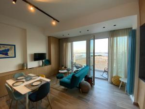 a living room with a table and a blue couch at Seaview Apartments in Palermo