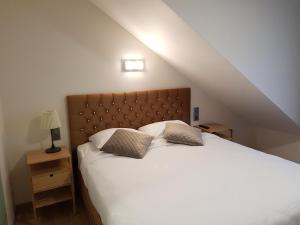 a bedroom with a large white bed with two pillows at Hôtel Méribel in Brussels +66 photos