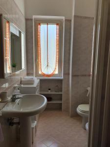 a bathroom with a sink and a toilet and a window at TraMonti e Mare in Tramonti