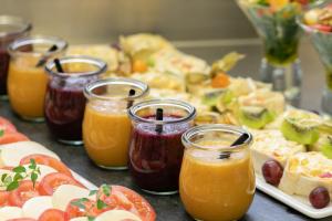 a table topped with plates of food and jars of juice at hotel bomonti Nürnberg West in Oberasbach