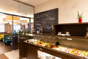 a breakfast buffet in a restaurant with a chalkboard at hotel bomonti Nürnberg West in Oberasbach