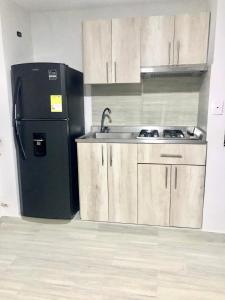 a kitchen with a black refrigerator and a sink at Caribbean Venture Apto 303 - Rodadero, Santa Marta in Santa Marta