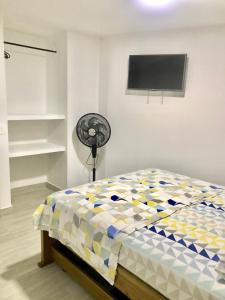 1 dormitorio con 1 cama y ventilador en Caribbean Venture Apto 303 - Rodadero, Santa Marta, en Santa Marta