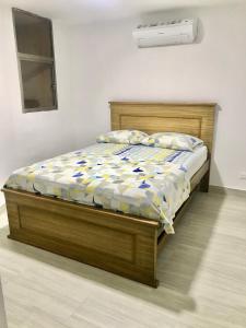 a bed with a wooden frame in a bedroom at Caribbean Venture Apto 303 - Rodadero, Santa Marta in Santa Marta