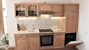 a kitchen with wooden cabinets and a sink at Kinderparadies Bachbauer in Mondsee