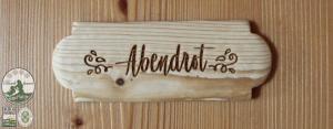a sign on a wooden wall with writing on it at Kinderparadies Bachbauer in Mondsee