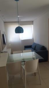勒西菲的住宿－Flat Graças，客厅配有玻璃桌和蓝色沙发