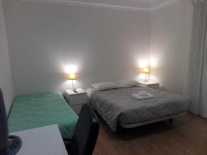 Dormitorio pequeño con 2 camas y 2 lámparas en Residence Metro-Alameda, en Lisboa