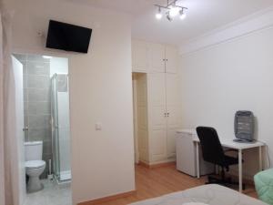 Jest to biały pokój z biurkiem i telewizorem na ścianie. w obiekcie Residence Metro-Alameda w Lizbonie