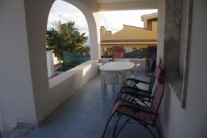 a patio with a table and chairs on a balcony at Villa Isolde in Triscina +56 photos