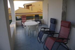 a patio with a table and chairs on a balcony at Villa Isolde in Triscina