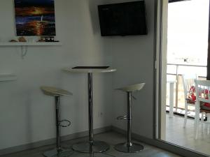 Habitación con 2 taburetes y TV de pantalla plana. en Beau T2 Climatisé sur Marina avec parking privé, en Canet-en-Roussillon