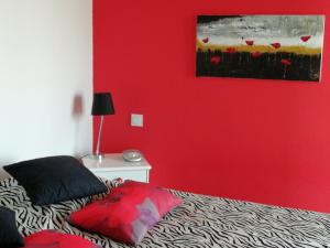 Habitación roja con cama y pared roja en Beau T2 Climatisé sur Marina avec parking privé, en Canet-en-Roussillon