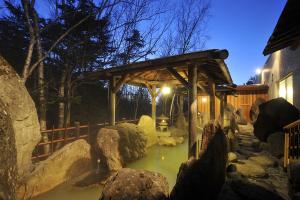 un estanque en un zoológico con estructura de madera en Taisetsuzan Shiroganekankou Hotel, en Biei