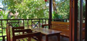 a wooden bench and a table on a porch at Hong Bin Bungalow in Phú Quốc