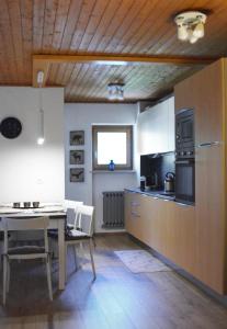 Appartamenti Ladina في بادولا: مطبخ وغرفة طعام مع طاولة وطاولة وكراسي
