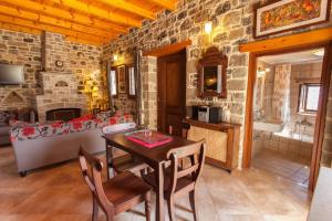 a living room with a table and a stone wall at Diktynna Traditional Villas in Anatolí