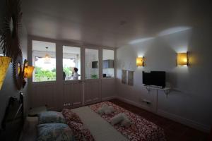 een slaapkamer met een bed, een tv en een raam bij Jolie studio meublé avec petite vue mer in Saint-François