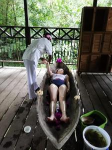 a woman laying in a bath tub with a person standing at Casa Colibrí in Nuquí