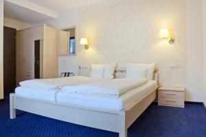 a large white bed in a hotel room at City-Hotel in Friesoythe