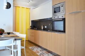 cocina con microondas y mesa con sillas en Appartamenti Ladina en Padola