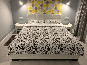 a bedroom with a bed with a black and white bedspread at Travel Homzzz Central Apartments - Piata Trandafirilor in Târgu-Mureş
