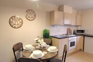 a kitchen with a table and chairs in a kitchen at Sunnydale Serviced Apartments - Central location, with allocated parking in Wakefield
