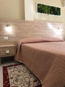 - une chambre avec un grand lit et une tête de lit en bois dans l'établissement Hotel Centrale, à Quartu SantʼElena