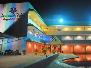 a large building with a swimming pool at night at Chiang Rai Park Resort in Chiang Rai