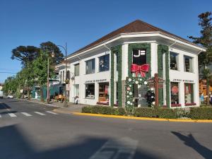 un edificio blanco con un arco rojo en una calle en Cobertura Roloff, en Gramado