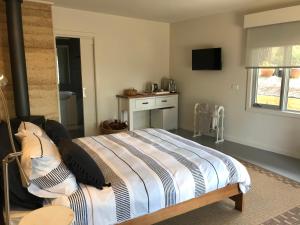 a bedroom with a bed and a table and a window at SIGNAL BOX Short Stay in Gembrook +14 photos