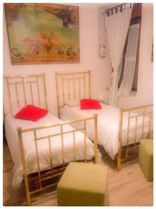 2 letti con cuscini rossi in una stanza di Elizabeth B&B a Lentigione