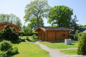 a small wooden cabin in a yard with a path at Strand Quartier in Timmendorfer Strand