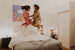 dos niños saltando sobre una cama en aDuquesa - GuestHouse, en Oporto