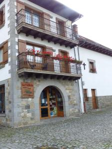 un edificio con 2 balcones y flores. en Gaztanbide Apartamento rural en Ochagavía