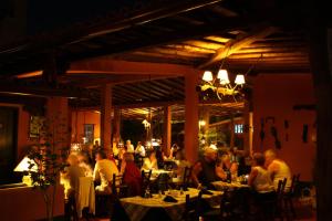 un grupo de personas sentadas en mesas en un restaurante en Hotel Costa Linda Beach en La Loma