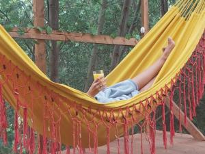 a woman laying in a hammock holding a cell phone at Glamping con sentido in Subachoque