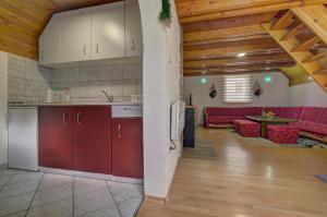 an open kitchen and living room with a red couch at Villa Strahinja Lux Jahorina in Jahorina
