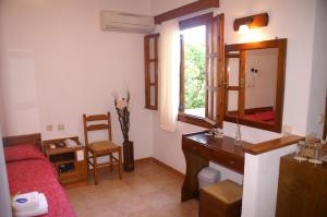 a bedroom with a bed and a desk and a mirror at Drymna in Trizonia +36 photos