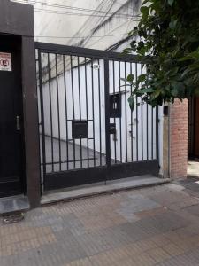 a black gate in front of a building at La Rojarilla in San Miguel de Tucumán