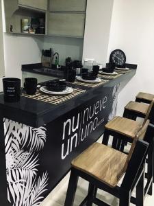 a kitchen with a counter with chairs and a counter top at Nueve Uno Hostel in Ríohacha